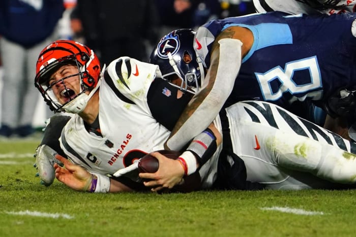 Cincinnati Bengals quarterback Joe Burrow (9) is sacked in the fourth quarter during an NFL divisional playoff football game against the Tennessee Titans, Saturday at Nissan Stadium in Nashville. The Cincinnati Bengals defeated the Tennessee Titans, 19-16, to advance to the AFC Championship game.
